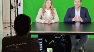 Operador de cámara grabando a dos presentadores delante de un croma verde en el plató de Yumagic